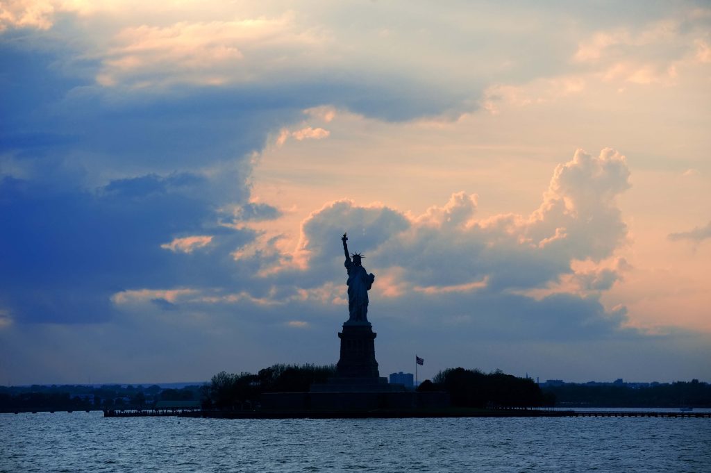 The Statue of Liberty seen as a silhouette against the evening sky